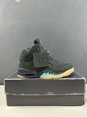 Side view of a dark green and black Jordan Air Jordan 5 sneaker with aqua midsole accents, displayed on a shoe box.
