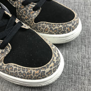 Close-up of the black perforated toe box bordered by leopard-print overlays.