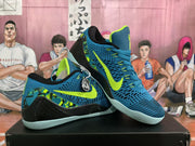 Angled side view highlighting the blue upper, bright green swoosh, black overlays and pale outsole.