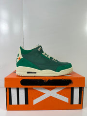 Green and off-white high-top sneaker displayed on an orange Jordan shoebox.