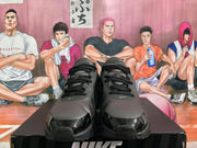 Front view of black and silver Nike sneakers showing the laces, swoosh details, and textured toe area.