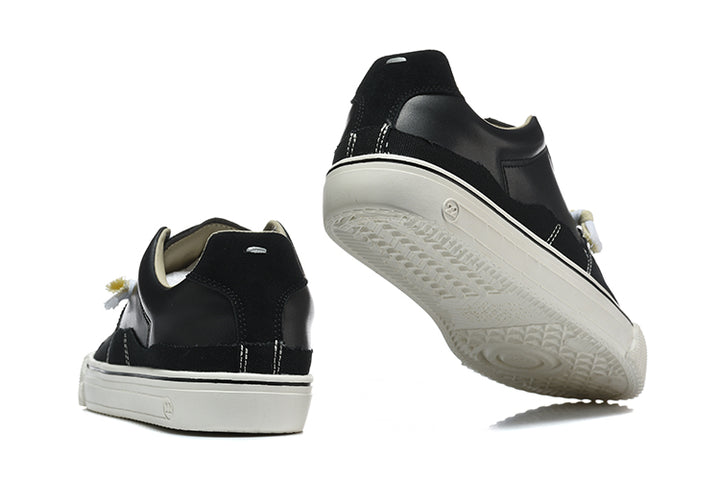 Black sneakers shown from the rear and underside, with a white sole.