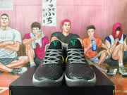Front view of black Nike basketball shoes with grey laces and green tongue logos.