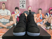 Front view of the black high-top basketball sneakers showing the layered strap construction, textured uppers, and translucent soles.