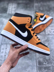 Angled side view showing the orange heel and forefoot panels, black upper, white Swoosh, and white midsole.