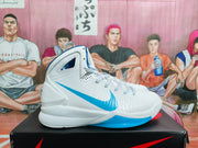 Side view of a white Nike basketball shoe with a blue Swoosh and blue outsole accent
