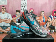 Angled view of the paired basketball sneakers showing the textured upper, contrasting heel panels, and visible Zoom midsole text.