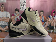 Side view showing the beige upper, black sole sections, pink Nike swoosh, and lace-up construction.