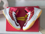 Pair of shoes displayed over a red shoe box
