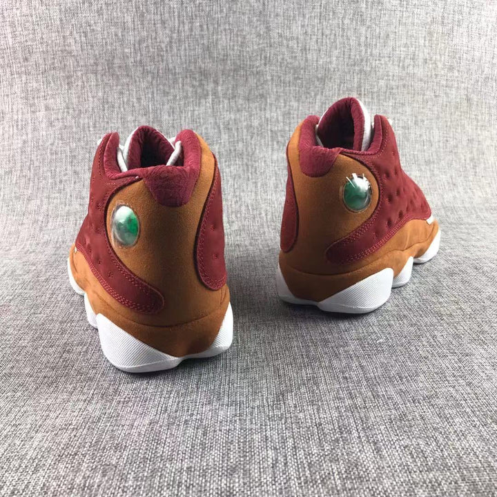 Rear view of burgundy and brown high-top sneakers with circular heel details and white soles.