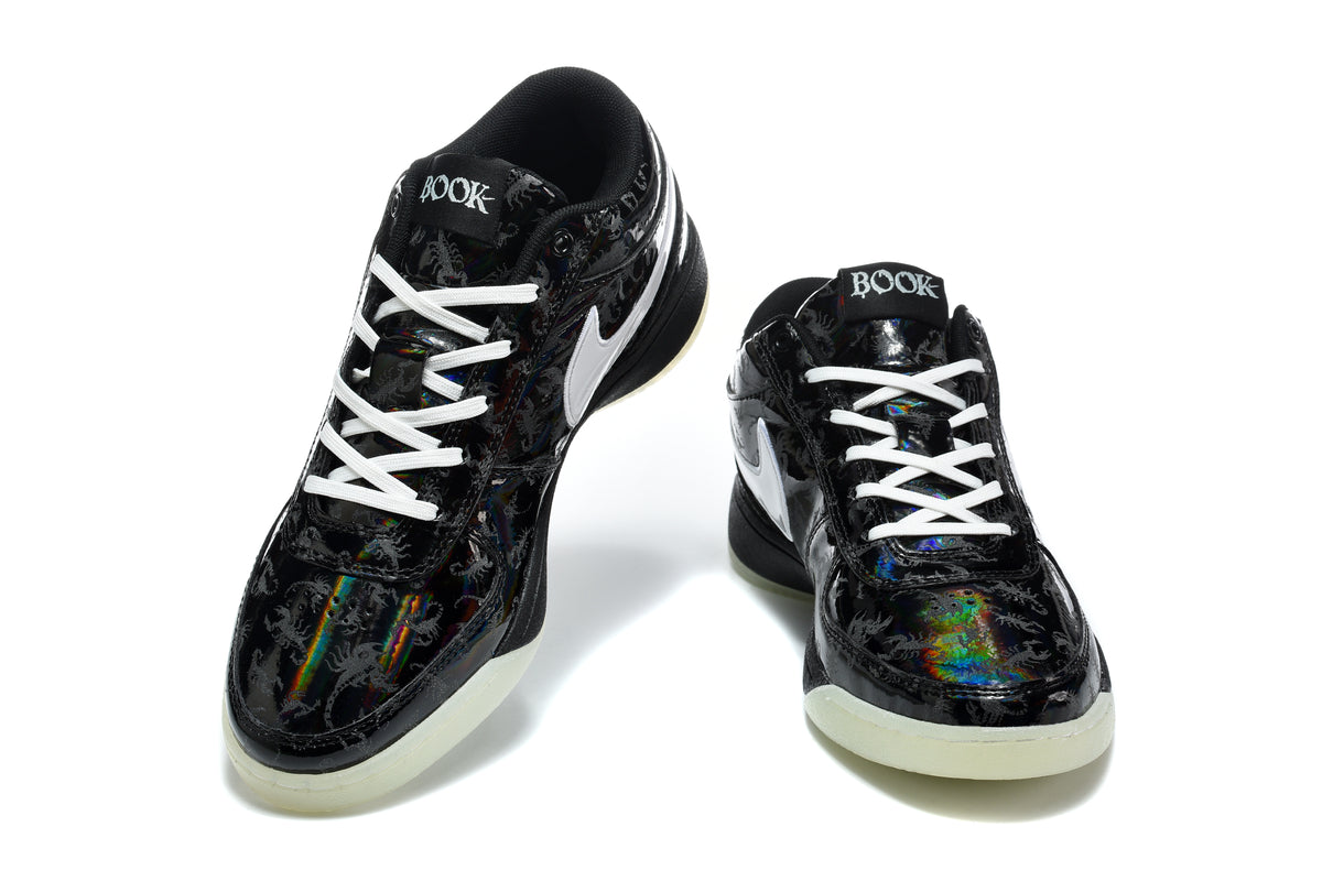 Pair of black and white low-top sneakers shown from the front, with white laces and glossy patterned uppers.