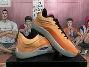 Angled view of the orange and black Jordan sneakers displayed one over the other on a shoebox.
