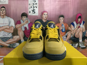 Front view of the pair showing yellow toe boxes, black mesh panels, yellow laces, and branded tongues.