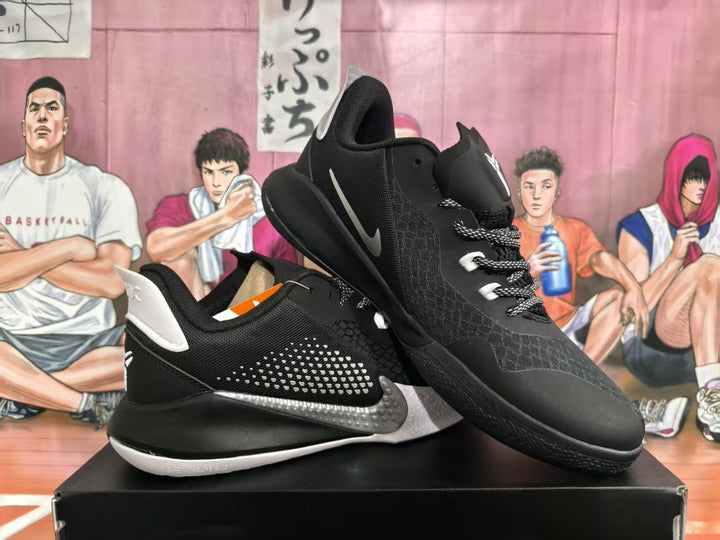Pair of black Kobe basketball sneakers with gray side details, white accents, and patterned laces displayed on a shoebox.