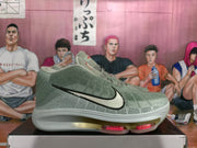 Side profile of a green basketball sneaker showing the black Swoosh, white midsole, translucent outsole, and red cushioning elements.