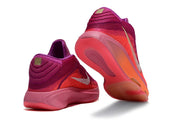 Pink and purple Nike GT Hustle 3 shoes shown from heel and outsole angles.