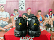 Rear view of black Nike sneakers showing heel branding and visible cushioning windows.