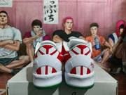 Rear view showing white heel panels with red geometric detailing and green outsole edges.