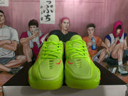 Front view of fluorescent green Nike basketball sneakers with red Swoosh accents and matching laces.