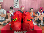 Front view of red Nike high-top sneakers showing the upper fastening panels and yellow-and-black side accents.