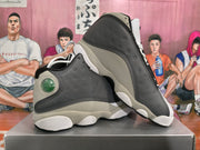 Pair of gray, black, and white Jordan sneakers arranged to show their side panels and heel accents.