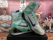 Angled view of the pair highlighting the green patterned upper, purple Swooshes, black side inserts, and high-top collars.