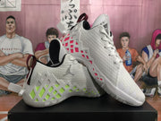 Angled view of the white Jordan sneaker pair showing mismatched neon green and pink geometric side accents, lace-up fronts, and textured outsoles.