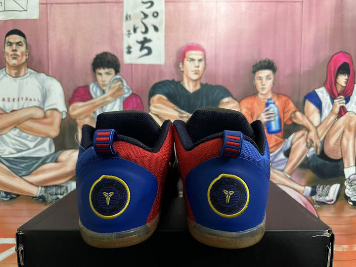 Rear view of navy, blue and red basketball shoes with heel emblems and translucent brown-toned outsoles.
