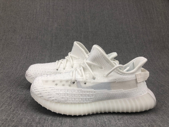 Pair of white knit-look kids sneakers shown from a side angle on a gray background.