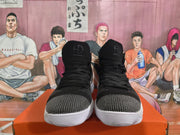 Front view of black high-top Nike sneakers with gray toe details, black laces, and white soles.