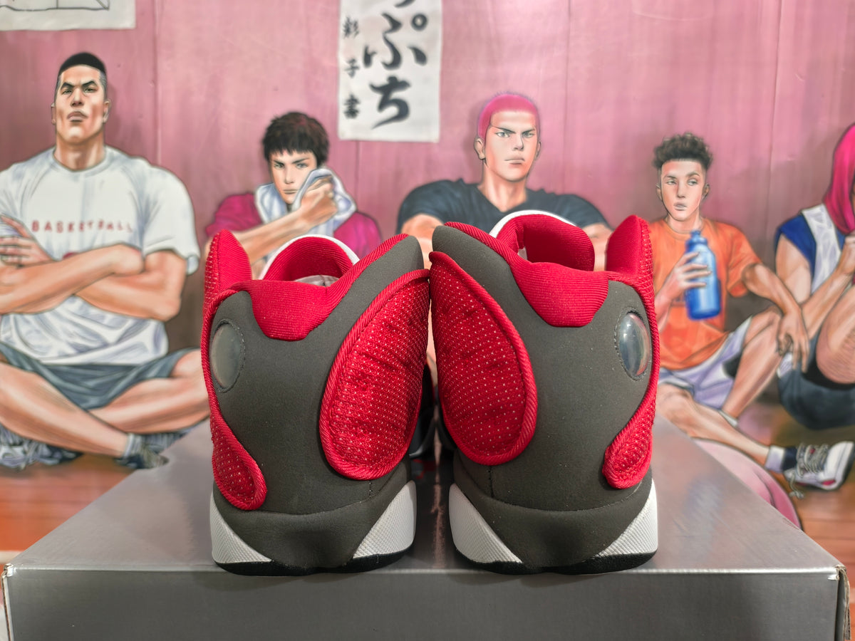 Rear view of gray, black, red, and white high-top basketball sneakers on a box.