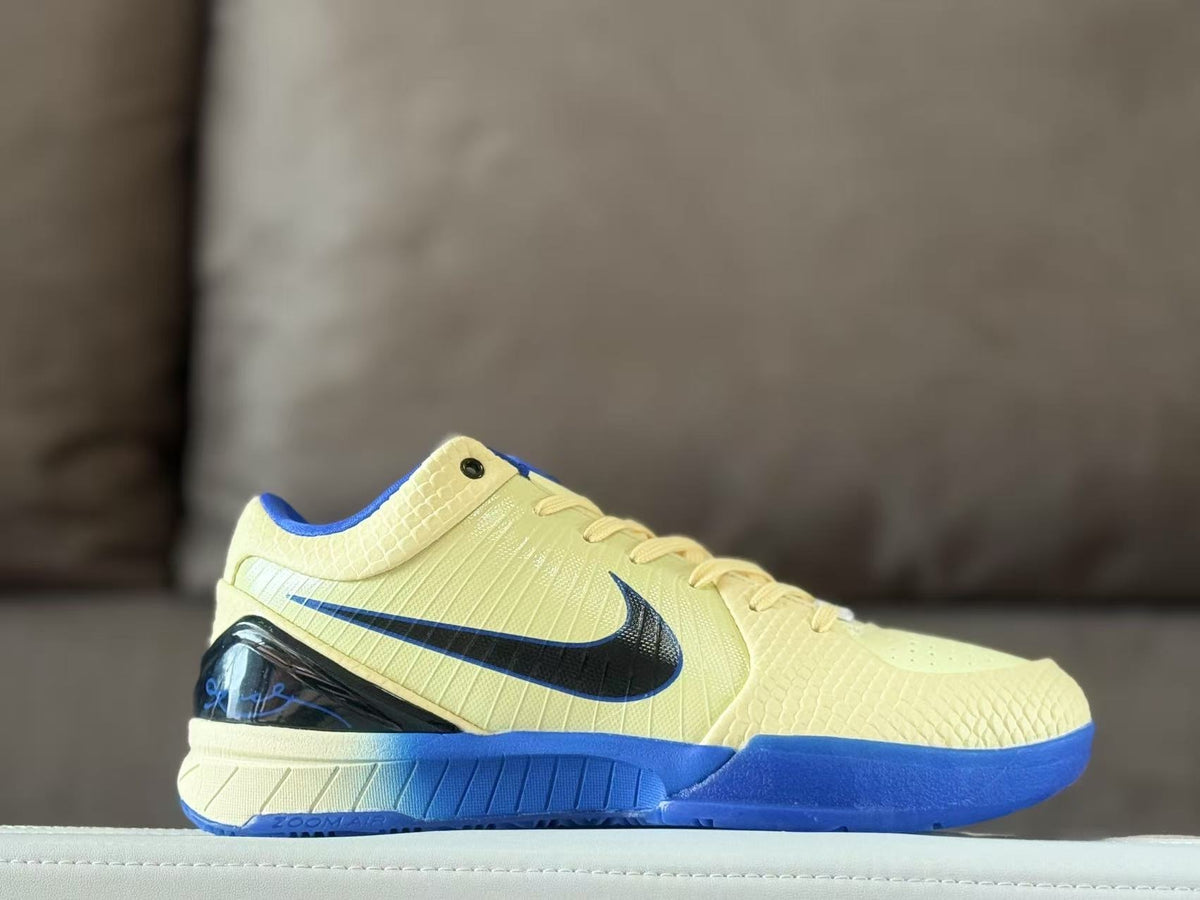 Side profile of a pale yellow Nike Kobe 4 basketball sneaker with a black Swoosh, blue outsole and glossy black heel section.