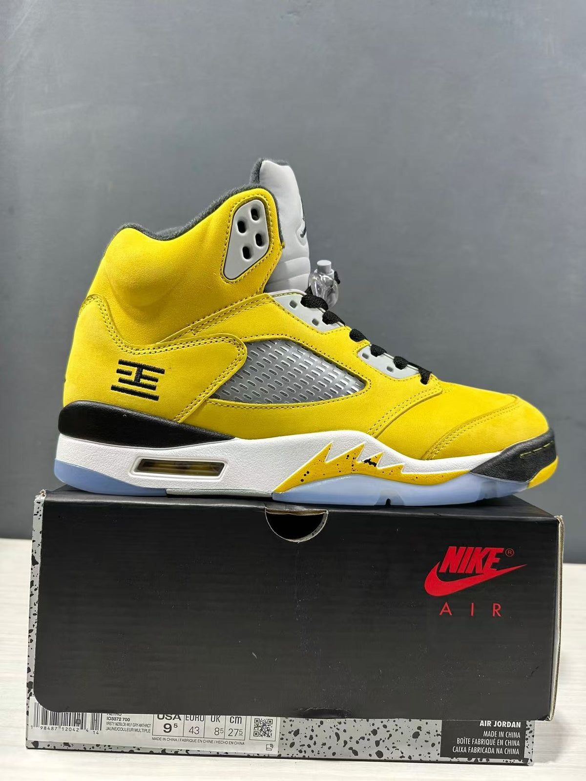 Yellow Jordan Air Jordan 5 sneaker displayed on its box, with the box label visible.
