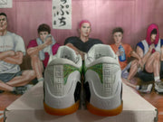 Rear view showing the white heel structure, green patterned heel panels, Kobe heel branding, and gum-colored outsoles.