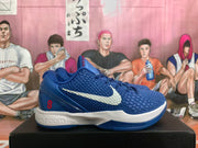 Side view of a blue Nike Kobe basketball shoe with a textured upper, white Swoosh, and red heel number 8.