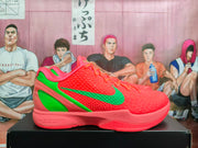 Side profile of a coral Nike Kobe PE basketball shoe with green details