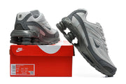 Grey Nike Shox Ride 2 sneakers beside a red shoe box; the box label shows a sample size.