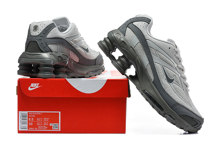 Grey Nike Shox Ride 2 sneakers beside a red shoe box; the box label shows a sample size.