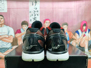 Rear view of black and red Nike basketball sneakers resting on a black shoebox.