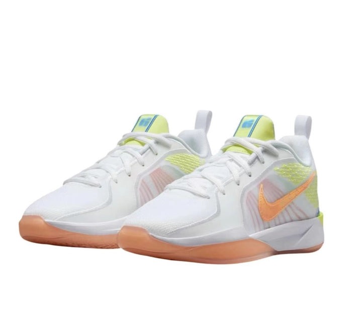 Pair of white Nike basketball sneakers with orange Swoosh accents, pale yellow-green details, and gum-colored outsole sections.