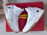 Pair of white high-top basketball shoes displayed on a red box