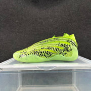 Lime-green sneaker with black snake-like patterning in a side view