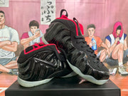 Angled view of the black and red sneakers displaying the molded side panels and lace-up construction.