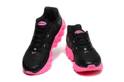 Front and top views of black sneakers with pink tongue labels and pink soles