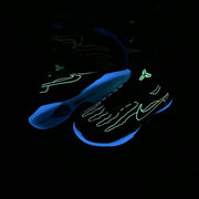 Pair of blue Nike-style basketball shoes with skull graphics shown under dark lighting