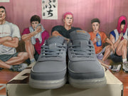 Front view of gray Nike low-top sneakers with tonal laces, perforated toe areas, and layered panels.