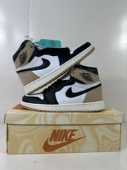 Pair of brown, black, and white high-top sneakers arranged on a shoe box, with turquoise hang tags visible.
