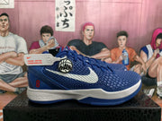 Side view of a blue Nike Kobe basketball shoe with a white swoosh, red number 8, and white midsole.