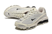 Pair of cream and grey Nike Shox Ride 2 sneakers in angled views.