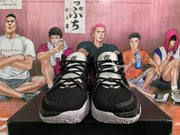 Front view of black and white Nike basketball sneakers showing black laces, mesh-textured uppers, white tongues, and contrasting outsoles.